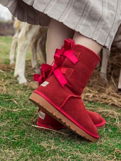 A bold double-bow detail in back puts a fun feminine twist on the classic shearling style in these genuine leather boots. A plush faux fur lining cushions your feet in supreme softness and warmth. 1'' heel 6.7'' shaft 13.4'' circumference Pull-on Leather Suede upper Faux fur lining Man-made sole Sheepskin Round Toe Boots, Fall Boots With Bow And Round Toe, Winter Boots With Bow And Round Toe, Red Ugg Boots, Red Uggs, Double Ribbon Bow, Genuine Leather Boots, Double Bow, Shearling Boots