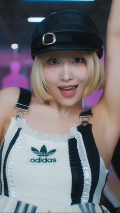 a woman with blonde hair wearing a black and white dress, hat and suspenders