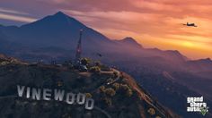 an airplane flying over the top of a mountain with a sign that reads vinewood