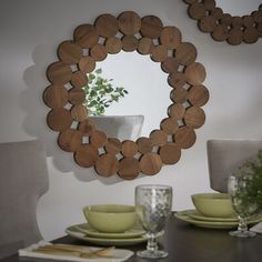 a dining room table with plates and cups on it, in front of a mirror