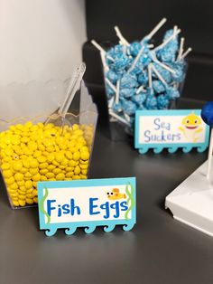 fish eggs are sitting in plastic containers on a table next to marshmallows