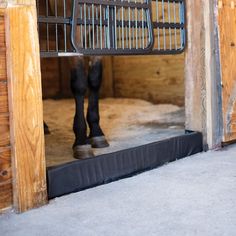 a horse is standing in the stable with its feet on the ground and it's head sticking out