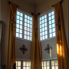 two large windows with yellow curtains in a living room