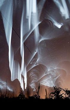 the sky is lit up with long exposures and light from an object in it