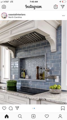 a kitchen with blue tiles on the backsplash and green apples in a bowl