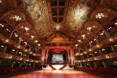 an ornately decorated auditorium with red chairs