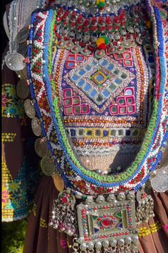 a woman's colorful beaded dress with coins on the chest and belt around her waist