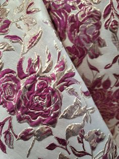 the fabric has been embroidered with pink and silver flowers