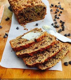 sliced loaf of banana bread sitting on top of a cutting board next to blueberries