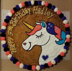 a birthday cake decorated with an image of a unicorn