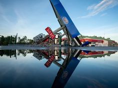 a gas station that has been knocked over by the wind and is partially submerged in water