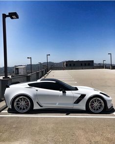 a white sports car parked in a parking lot