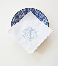 two blue and white plates with napkins on them, one has a cross in the middle