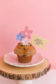 a cupcake on a plate with a happy mother's day sign next to it