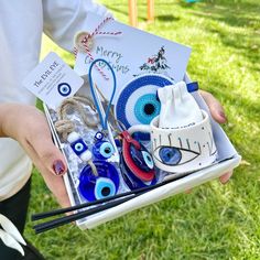 a person holding an open box filled with assorted eyeballs and other items in it