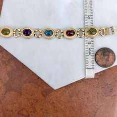 Estate/ vintage 14KT yellow gold Byzantine design, textured + cabochon, multi-gemstone link bracelet. Textured, shiny, and matte finishes on this piece. Slightly concave pieces with cabochon, amethyst, blue topaz, garnet, peridot, and citrine oval gemstones. Each gemstone measures: 7mm x 5mm; (8) total Rectangle byzantine + shiny open design links bracelet Measures 7.5", but fits shorter when clasped at the shorter length Weight: 22 grams Measures: 10mm wide Secure snap clasp Stamped 14K Great v Formal Jewelry With Oval Cabochon Natural Stones, Oval Multicolor Jeweled Jewelry, Formal Oval Cabochon Natural Stone Jewelry, Gold Jewelry With Gemstone Accents In Oval Cabochon, Gold Jewelry With Gemstone Accents And Oval Cabochon, Gold Jewelry With Gemstone Accents, Oval Link Gemstone Bracelet For Gift, Vintage 14k Gold Oval Link Bracelet, Byzantine Oval Gemstone Jewelry