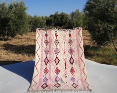 a blanket is laying in the snow near an olive tree filled field with grass and trees