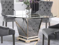 a glass table with grey chairs around it