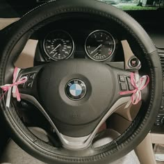 the steering wheel is decorated with pink ribbon and bows for someone to put on their car