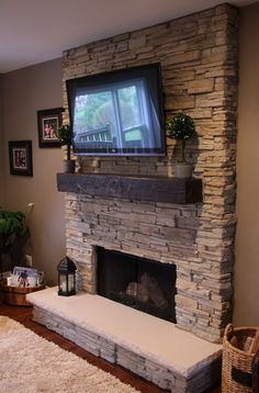 a living room with a television mounted on the wall above a fire place in front of a fireplace