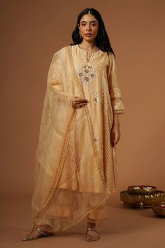 Peach brocade panelled kalidaar kurta with floral, thread and mukaish hand embroidery. Paired with pant and dupatta.
Components: 3
Pattern: Embroidered
Type Of Work: Floral
Neckline: Notched v neck
Sleeve Type: Three quarter
Fabric: Silk Chanderi
Color: Peach
Other Details: 
Lace detailing
Floral embroidery
Occasion: Mehendi and Haldi - Aza Fashions Traditional Peach Wear With Zari Work In Traditional Drape, Festive Chikankari Embroidery Palazzo Set In Tissue Silk, Festive Tissue Silk Palazzo Set With Chikankari Embroidery, Traditional Peach Wear With Zari Work, Festive Peach Traditional Wear With Chikankari Embroidery, Transitional Tissue Silk Kurta With Gota Work, Peach Raw Silk Traditional Wear With Resham Embroidery, Peach Resham Embroidered Raw Silk Traditional Wear, Peach Traditional Wear In Raw Silk With Resham Embroidery