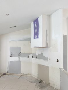 an unfinished kitchen with white cabinets and tile flooring in the process of remodeling