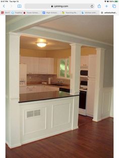 an empty kitchen with wood floors and white cabinets