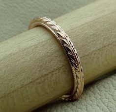 a close up view of a wedding ring on a wooden surface with a green cloth in the background