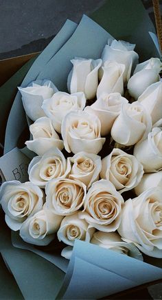 a bouquet of white roses in a box