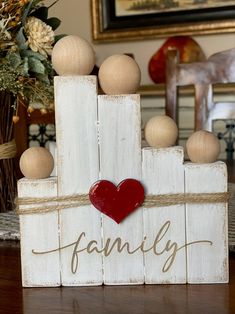 a wooden block with a heart on it and the word family spelled in cursive writing