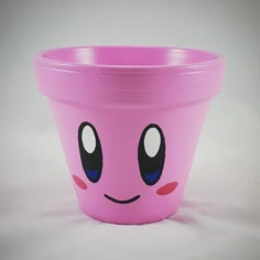 a pink plastic cup with a face drawn on the side and eyes painted on it