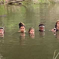 several people are swimming in the water with one person holding a camera up to their face