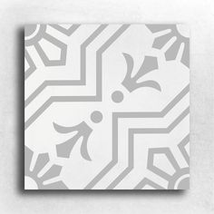 a white and gray tile with an abstract design on the bottom half of it,