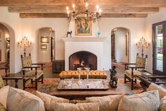 a living room with couches, chairs and a fire place in the middle of it