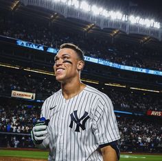 a baseball player with his face painted like a new york yankees fan at a game