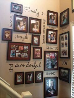 a wall filled with pictures and family names on the wall next to a stair case