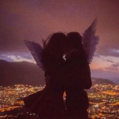 two people are kissing in front of the city lights