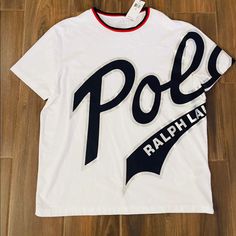 It’s A White T-Shirt With Polo Logo On It By Polo Ralph Lauren . It’s Brand New With Tags . Never Worn As Size Is Not Fit Cotton Logo Short Sleeve Tops, Short Sleeve Cotton Top With Logo, Cotton Logo Top With Short Sleeves, Casual Short Sleeve Shirt With Logo, Casual Short Sleeve Logo Top, White Cotton Top With Logo, White Short Sleeve Top With Logo, White Crew Neck Top With Logo, White Graphic Tee With Logo