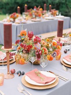 the table is set with pink and orange flowers