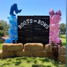 two giant balloons sitting on top of hay bales in front of a sign that says boots or bows