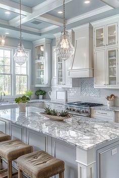 a kitchen with white cabinets and marble counter tops, two stools in front of the island