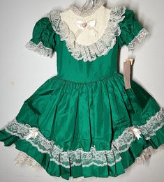 Brand new 80's vintage green dress with lace, flowers, bows, button up back, and attached bow waist for adjustment and flair! Fluff n' Twirl Dress - labeled sz 6x measures pit to pit 13"/ waist 12" or smaller - can be tied back with sash bow / length (shoulder to bottom lace) 26"/ smoke-free environment / arm elastic is no longer functional due to age As Is due to sleeve elastic (115) 80s Fashion Kids, Vintage Green Dress, Lacey Dress, Vintage Girls Dresses, Dress Label, Circle Dress, Twirl Dress, 80s Dress, Childrens Dress