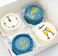 three decorated birthday cakes in a box with the numbers twenty and two champagne glasses on them