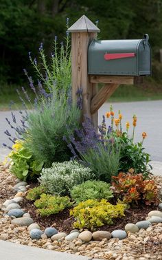 a mailbox surrounded by flowers and rocks