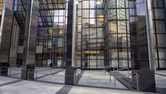 the entrance to an office building that has glass walls and metal railings on both sides