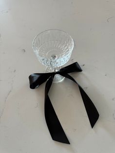 a glass bowl with a black bow on the side sitting on a white counter top