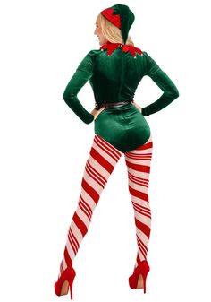 a woman dressed in green and red is standing with her hands on her hips while wearing striped stockings