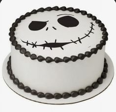 a white cake with black icing and a face on it's side,