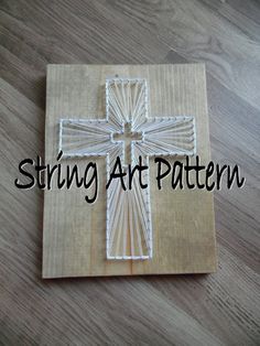 a cross made out of string on top of a wooden board with the words string art pattern