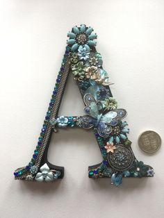 the letter a is made out of beads and other things that are attached to it